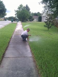a Brentwood Irrigation Repair member adjusts a sprinkler head